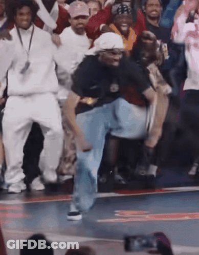 A Group Of People Are Dancing On A Basketball Court And One Of Them Is Wearing A Shirt That Says Nike On It GIF