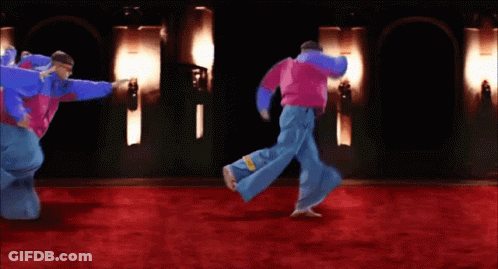 A Group Of People Are Dancing On A Red Carpet In A Dark Room GIF