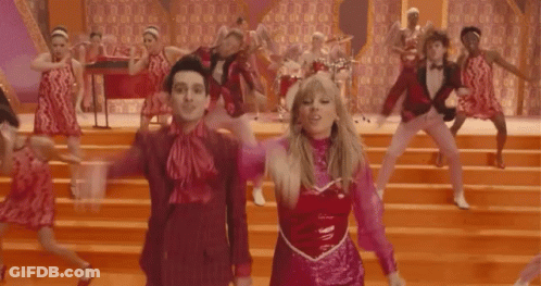 A Group Of People Are Dancing On A Stage And One Of Them Is Wearing A Pink Top GIF