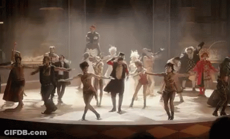 A Group Of People Are Dancing On A Stage In A Circus Show . GIF