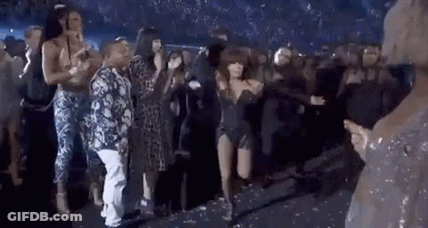 A Group Of People Are Dancing On A Stage In A Crowd . GIF
