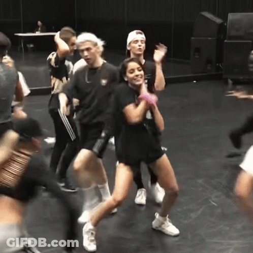 A Group Of People Are Dancing On A Stage In A Room . GIF