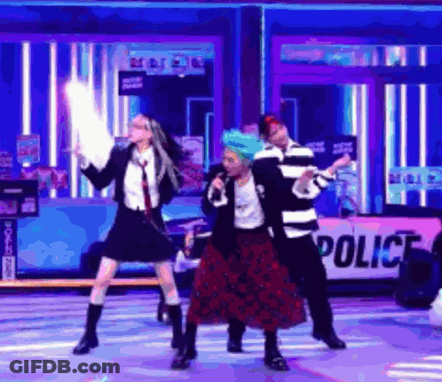 A Group Of People Are Dancing On A Stage With A Police Sign In The Background . GIF