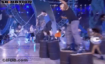 A Group Of People Are Dancing On A Stage With A Sign That Says Senation GIF