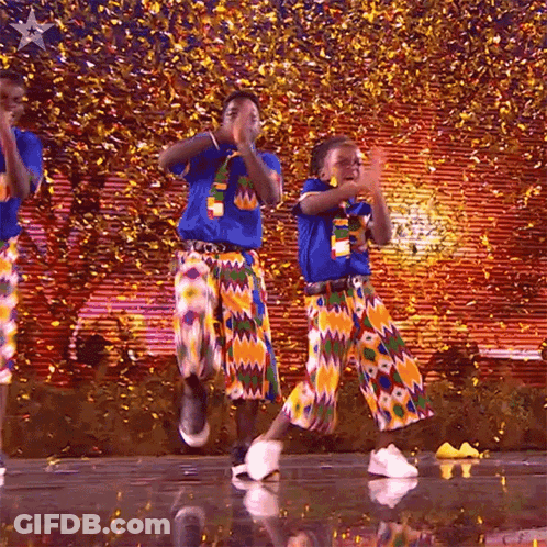 A Group Of People Are Dancing On A Stage With Confetti In The Background GIF