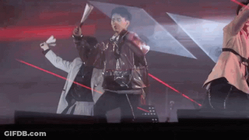 A Group Of People Are Dancing On A Stage With Red Lasers Behind Them . GIF