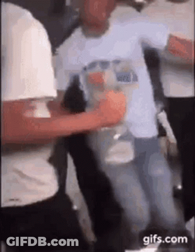 A Group Of People Are Dancing Together In A Room While A Man Is Holding A Bottle Of Water . GIF