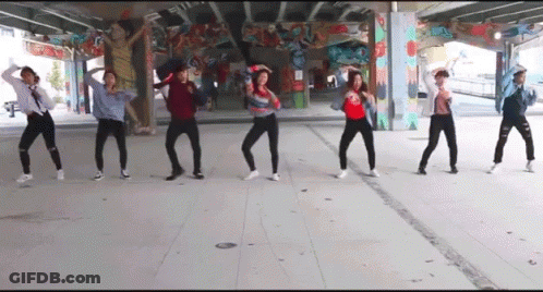 A Group Of People Are Dancing Under A Bridge In Front Of A Graffiti Wall . GIF
