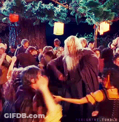 A Group Of People Are Dancing Under A Tree With Lanterns Hanging From It GIF