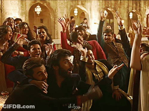 A Group Of People Are Dancing With Their Hands In The Air And The Word Shulgg Is Visible In The Corner GIF