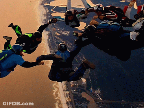 A Group Of People Are Flying Through The Air And One Of Them Is Wearing A Blue Shirt That Says ' Sd ' On It GIF