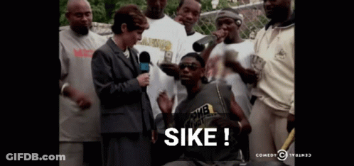 A Group Of People Are Gathered Around A Man With The Word Sike On The Bottom Right GIF