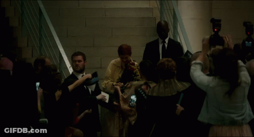 A Group Of People Are Gathered Around A Woman In A White Dress GIF