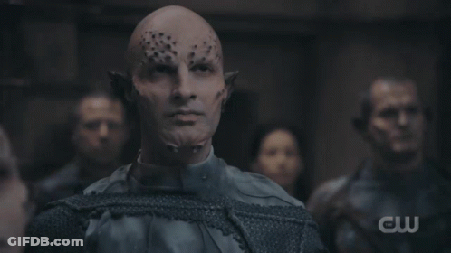 A Group Of People Are Gathered In A Dark Room With A Cw Logo In The Background GIF