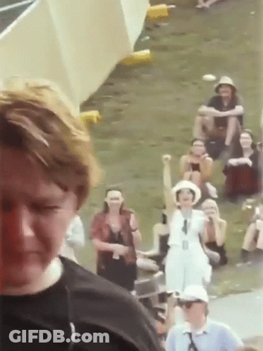 A Group Of People Are Gathered In A Field And One Woman Is Holding Her Fist Up In The Air GIF