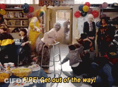 A Group Of People Are Gathered In A Room With Balloons And The Words Fire Get Out Of The Way GIF