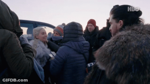 A Group Of People Are Gathered In Front Of A Car With Hbo On The Bottom Left GIF