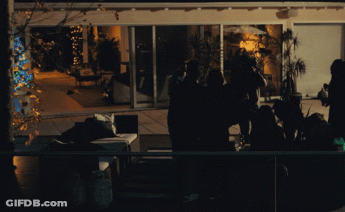 A Group Of People Are Gathered Outside A House At Night GIF