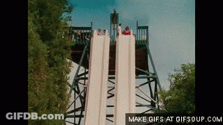 A Group Of People Are Going Down A Water Slide At A Theme Park GIF