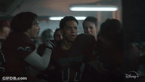 A Group Of People Are Huddled Together In A Dark Room With A Disney+ Logo In The Corner GIF