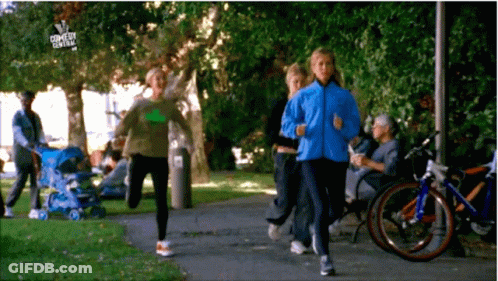 A Group Of People Are Jogging In A Park With A Sign That Says Comedy Central On It GIF