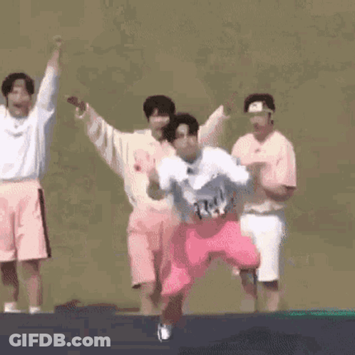 A Group Of People Are Jumping On A Trampoline And One Of Them Is Kneeling Down . GIF