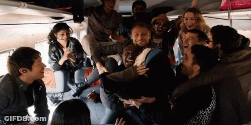 A Group Of People Are Laughing And Having Fun In A Room GIF