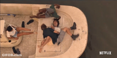A Group Of People Are Laying On A Boat With A Netflix Logo In The Corner GIF