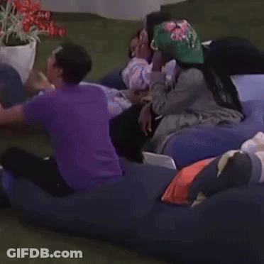 A Group Of People Are Laying On A Couch With One Wearing A Hat That Says ' A ' On It GIF