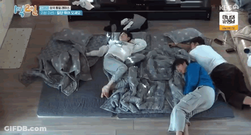 A Group Of People Are Laying On Top Of Each Other On A Mattress . GIF