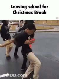 A Group Of People Are Leaving School For Christmas Break And Dancing On The Street . GIF