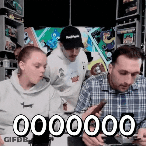 A Group Of People Are Looking At Their Phones And One Of Them Is Wearing A Hat That Says Veerfriends GIF