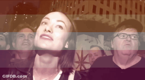 A Group Of People Are Looking Up At Something In Front Of A Sign That Says Pan GIF