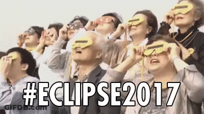 A Group Of People Are Looking Up At The Sky While Wearing Sunglasses . GIF