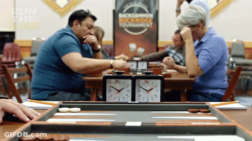 A Group Of People Are Playing A Game Of Backgammon In Front Of A Sign That Says " Run The Burbs " GIF