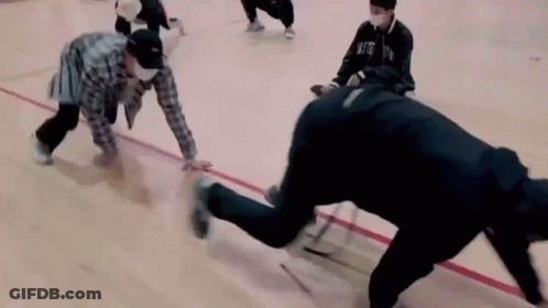 A Group Of People Are Playing A Game Of Ice Hockey On A Basketball Court . GIF