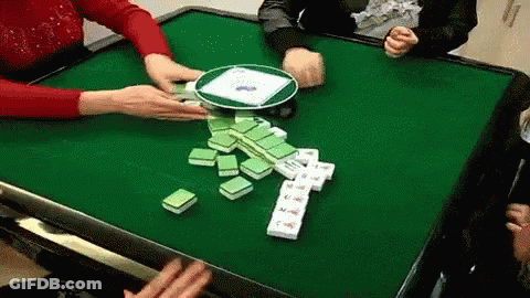 A Group Of People Are Playing A Game Of Mahjong At A Table . GIF