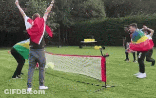 A Group Of People Are Playing A Game Of Tennis On A Grassy Field GIF