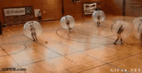 A Group Of People Are Playing Bubble Soccer On A Court GIF