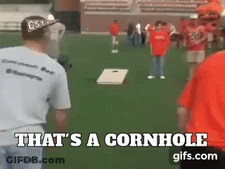 A Group Of People Are Playing Cornhole On A Field And The Caption Says That 'S A Cornhole GIF