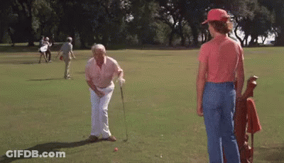 A Group Of People Are Playing Golf On A Green Field . GIF