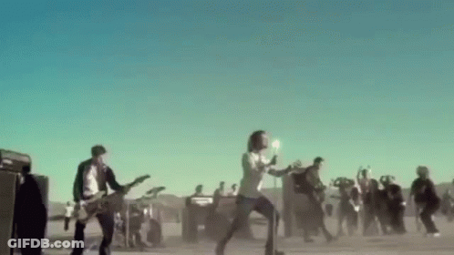 A Group Of People Are Playing Guitars And Singing In Front Of A Crowd . GIF