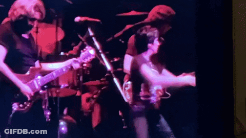 A Group Of People Are Playing Guitars And Singing On Stage . GIF