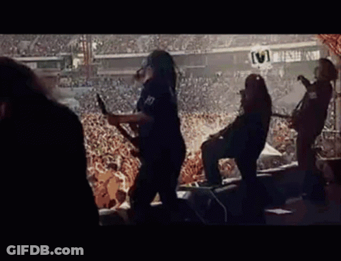 A Group Of People Are Playing Guitars In Front Of A Crowd . GIF