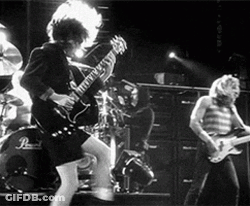 A Group Of People Are Playing Guitars On A Stage . GIF