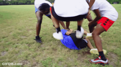 A Group Of People Are Playing In A Field And One Of Them Is Wearing Nike Shoes GIF