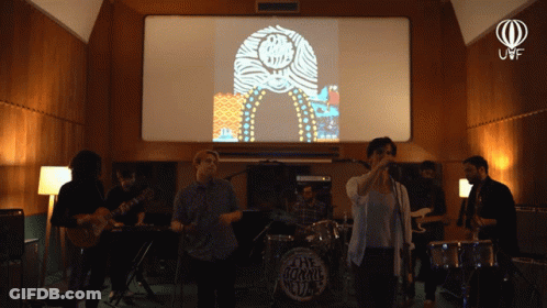 A Group Of People Are Playing Instruments In Front Of A Screen That Says The Jukebox Club GIF