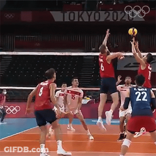 A Group Of People Are Playing Volleyball On A Court . GIF
