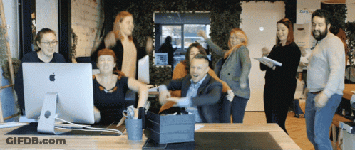 A Group Of People Are Posing For A Photo In Front Of An Apple Computer Monitor GIF