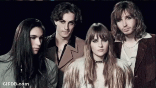 A Group Of People Are Posing For A Picture And One Of Them Is Wearing A Fur Coat GIF